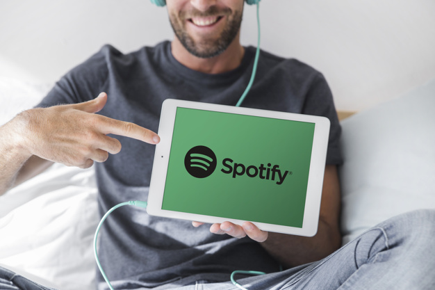man holding tablet with spotify app